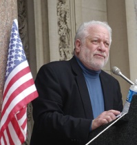 photo of Phil Berg with US flag in background